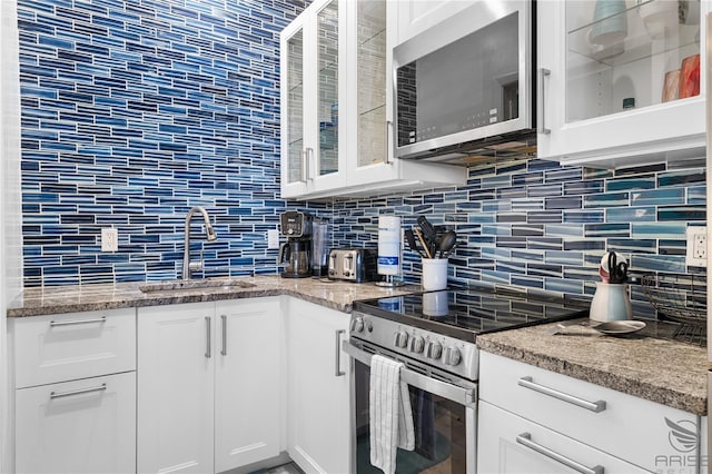 3509 S Atlantic Ave Unit 102And 103, New Smyrna Beach, FL 32169 - kitchen featuring stainless steel appliances, a sink, backsplash, and white cabinets