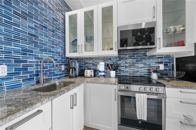 3509 S Atlantic Ave Unit 102And 103, New Smyrna Beach, FL 32169 - kitchen with appliances with stainless steel finishes, a sink, backsplash, and white cabinetry