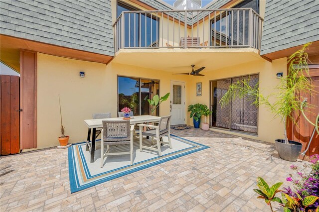 view of patio / terrace with a balcony, outdoor dining space, and ceiling fan