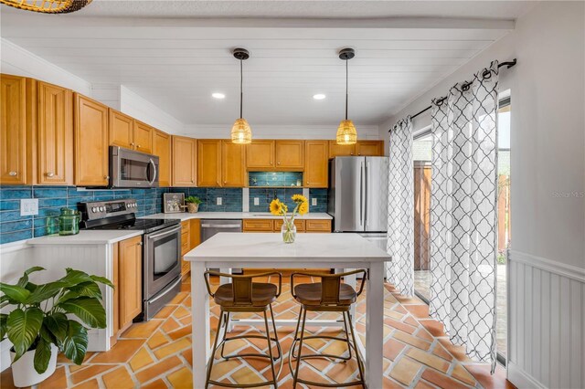 kitchen with appliances with stainless steel finishes, light countertops, tasteful backsplash, decorative light fixtures, and recessed lighting