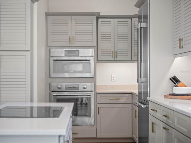 kitchen featuring stainless steel appliances, gray cabinetry, and light countertops