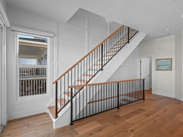 stairway featuring wood finished floors and baseboards