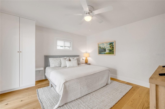 bedroom featuring light wood-style flooring, ceiling fan, and baseboards