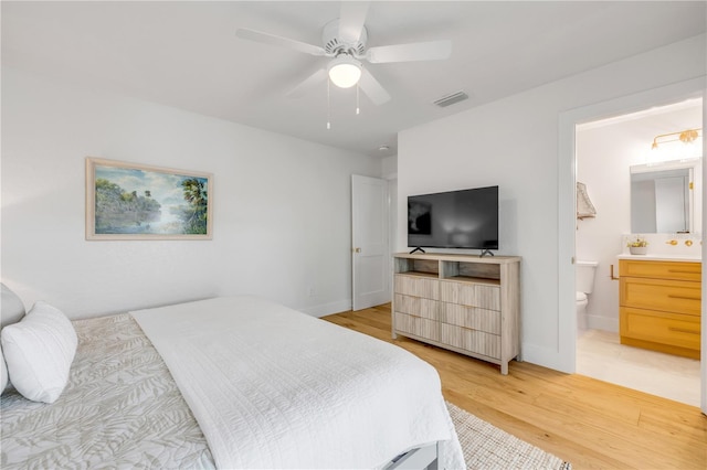 bedroom with light wood-style floors, connected bathroom, baseboards, and ceiling fan