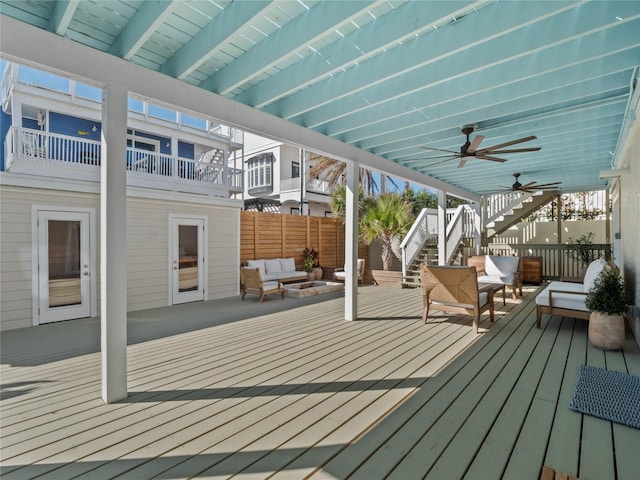 deck featuring outdoor lounge area, stairway, ceiling fan, and fence