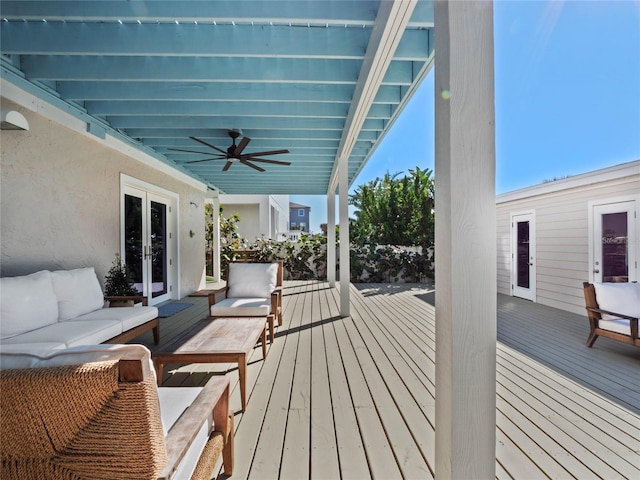 wooden terrace with an outdoor hangout area, a ceiling fan, and french doors