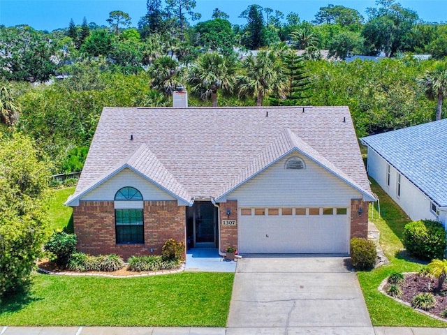 single story home with a front lawn, an attached garage, driveway, and brick siding