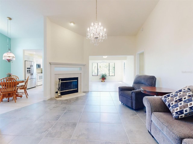living room with a chandelier, a fireplace, light tile patterned floors, and a high ceiling