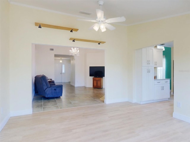 unfurnished room with ceiling fan, light wood-type flooring, a chandelier, baseboards, and crown molding