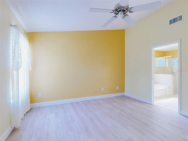 empty room with light wood-style floors, a ceiling fan, and baseboards