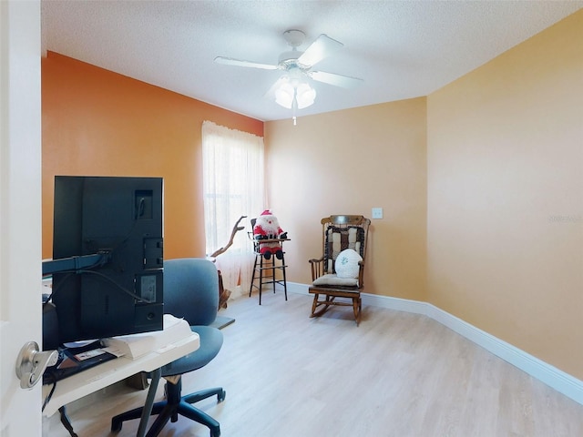 home office featuring wood finished floors, ceiling fan, baseboards, and a textured ceiling