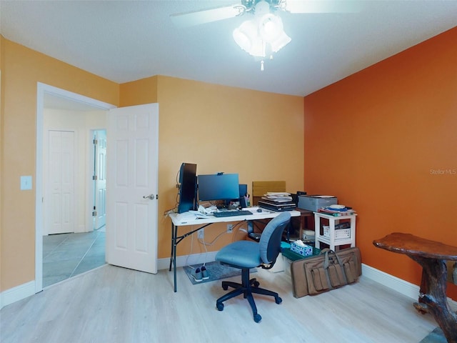 office featuring wood finished floors, baseboards, and ceiling fan