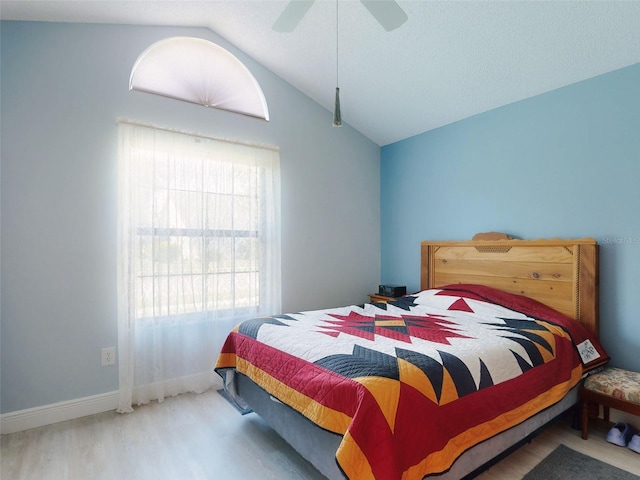 bedroom featuring vaulted ceiling, wood finished floors, baseboards, and ceiling fan