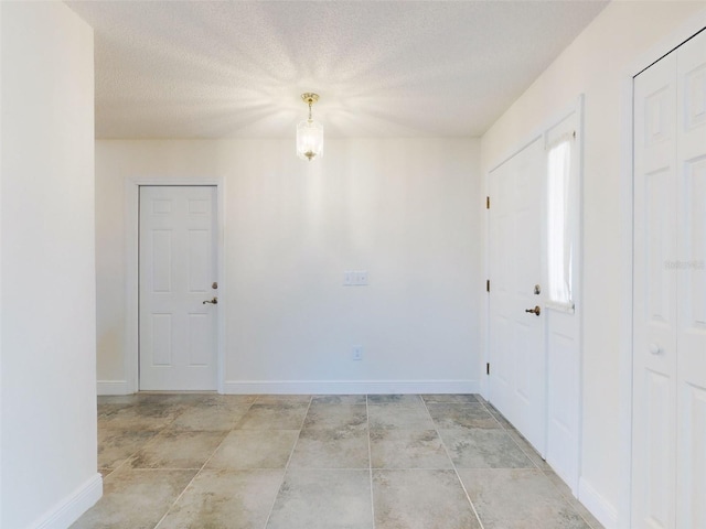 entrance foyer featuring baseboards and a textured ceiling