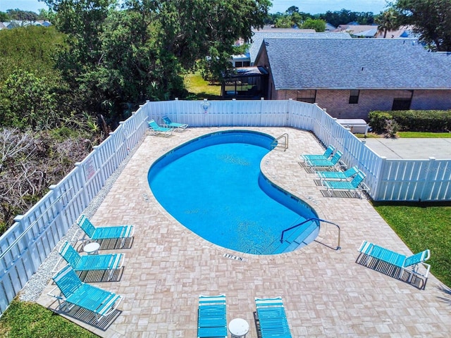 community pool featuring a fenced backyard and a patio