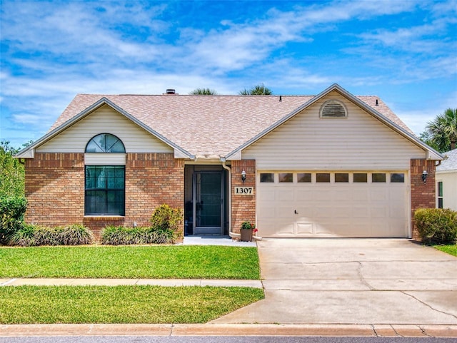 single story home featuring an attached garage, driveway, brick siding, a front lawn, and roof with shingles