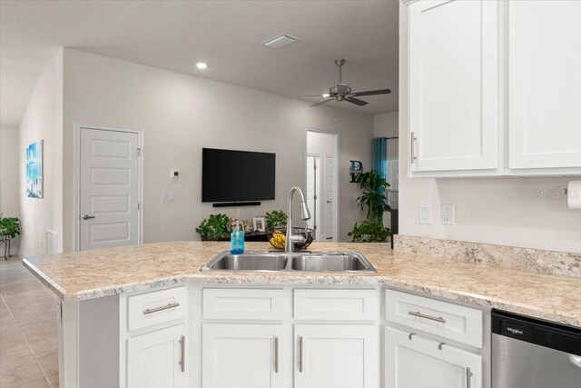 kitchen featuring a sink, dishwasher, a peninsula, ceiling fan, and white cabinets