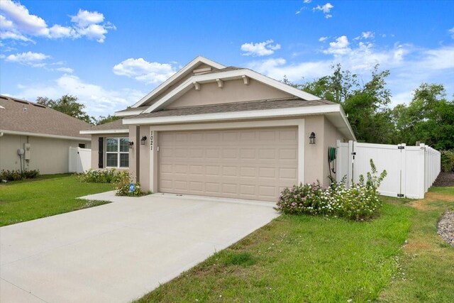 view of front of home with stucco siding, concrete driveway, a garage, and a gate