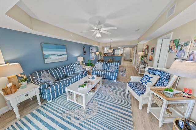 living room with ceiling fan, wood finished floors, and baseboards