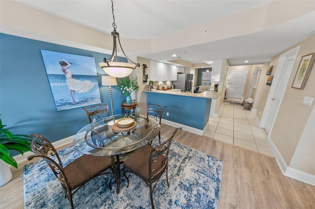 dining room with light wood-style floors and baseboards