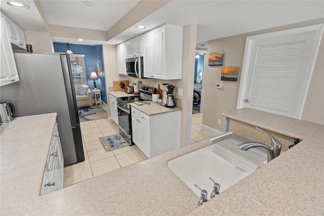 kitchen with stainless steel appliances, recessed lighting, white cabinets, light tile patterned flooring, and a sink