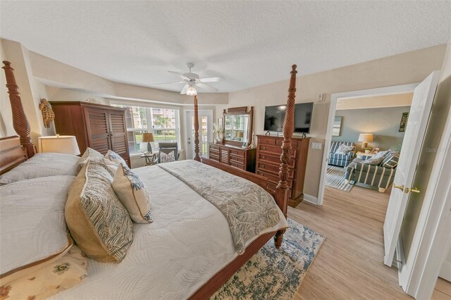 bedroom featuring light wood-type flooring, a textured ceiling, ceiling fan, and baseboards