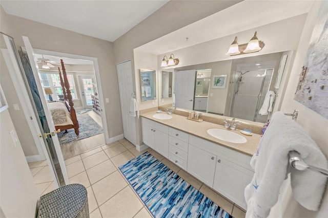 ensuite bathroom with a stall shower, double vanity, baseboards, tile patterned flooring, and ceiling fan