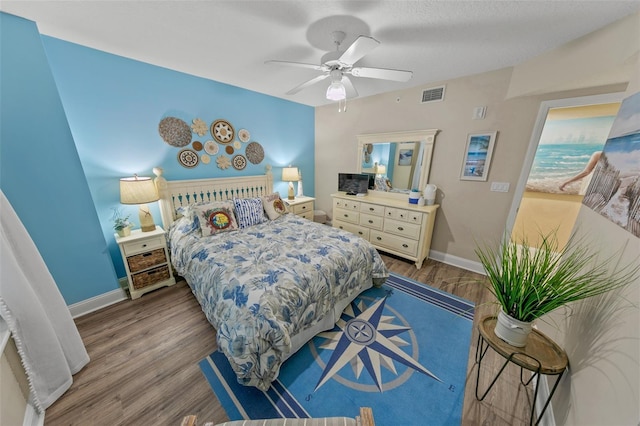 bedroom with wood finished floors, baseboards, and ceiling fan
