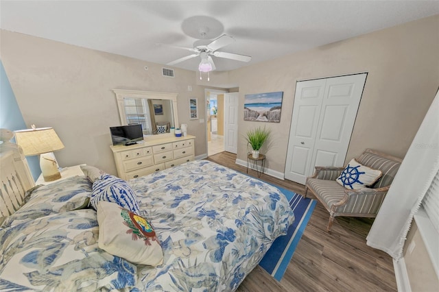 bedroom with wood finished floors, a closet, ceiling fan, and baseboards