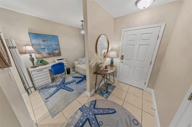 foyer entrance featuring baseboards and tile patterned flooring