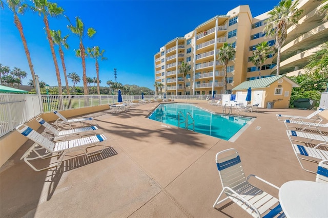 community pool with fence and a patio