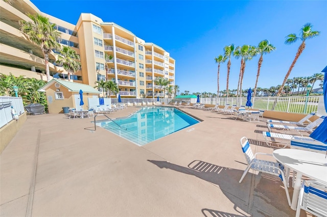 community pool with fence and a patio area