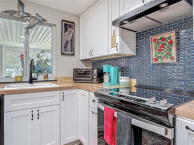 kitchen featuring wood counters, under cabinet range hood, electric range, a sink, and tasteful backsplash