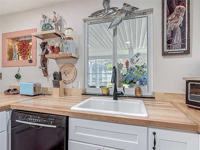 kitchen with wooden counters, dishwasher, a sink, white cabinetry, and open shelves