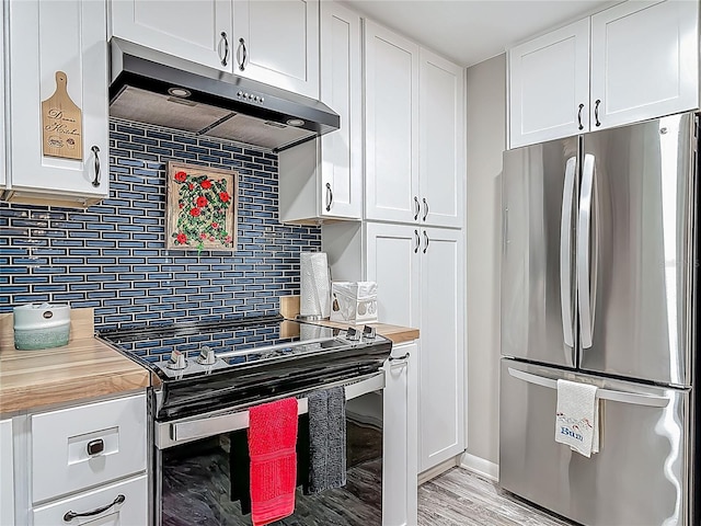 kitchen featuring freestanding refrigerator, under cabinet range hood, electric range, decorative backsplash, and white cabinetry