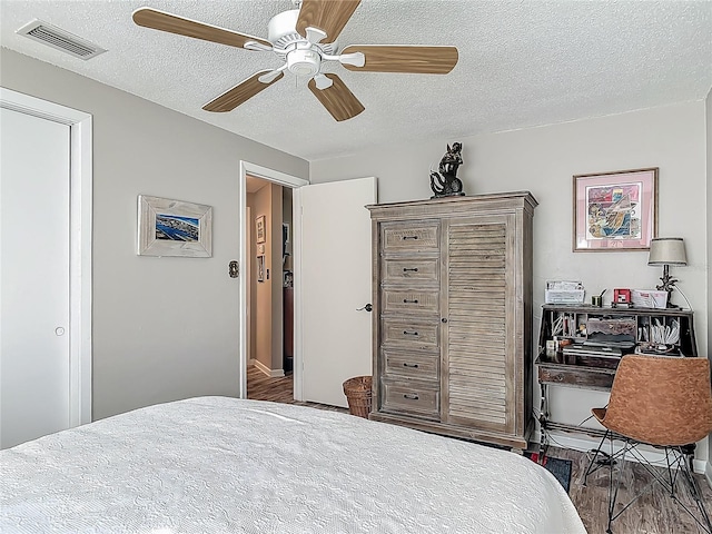bedroom featuring a textured ceiling, wood finished floors, and a ceiling fan
