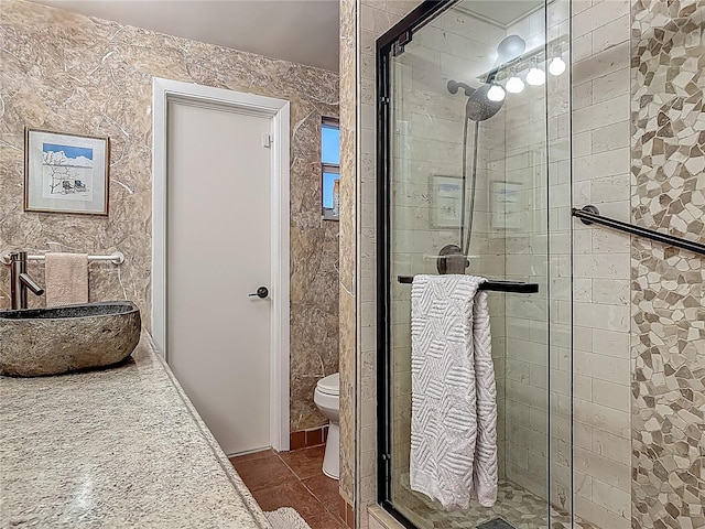 full bathroom featuring a stall shower, a sink, and toilet