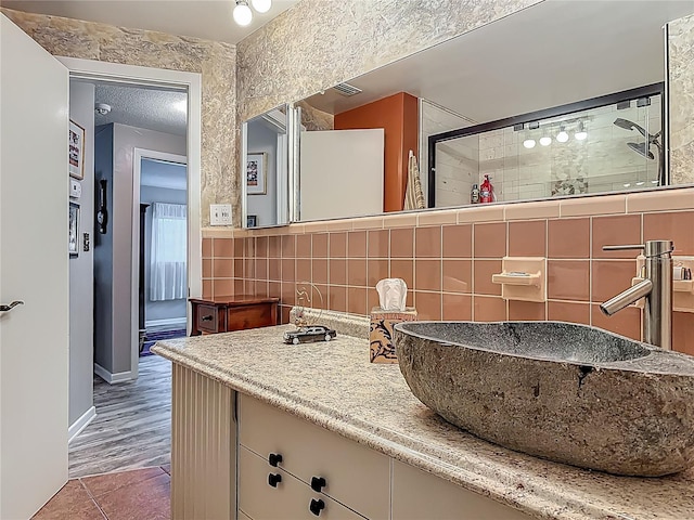 bathroom with baseboards, tasteful backsplash, and vanity