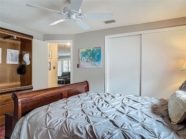 bedroom with a closet, a ceiling fan, and a textured ceiling