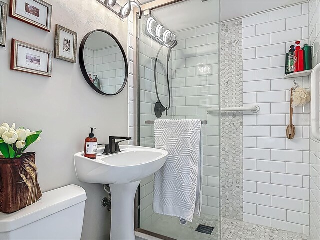 bathroom featuring a stall shower and toilet