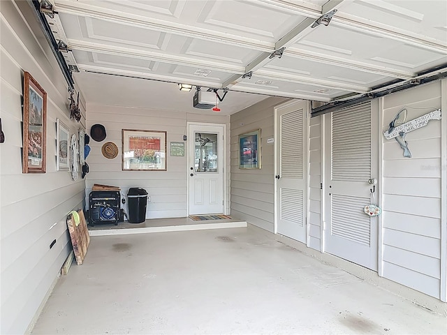 garage with a garage door opener and wooden walls