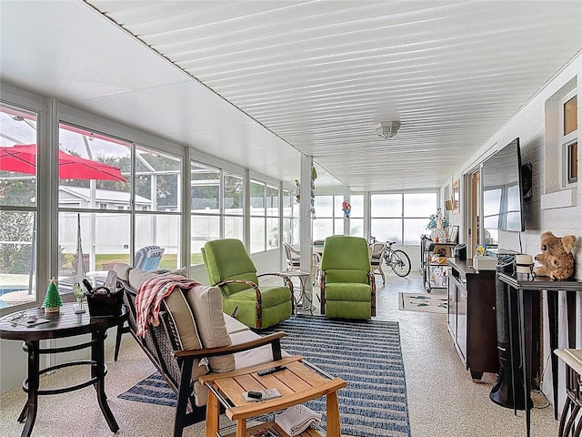 sunroom / solarium featuring speckled floor