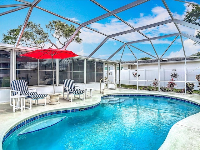 view of swimming pool with a patio area, fence, and a lanai
