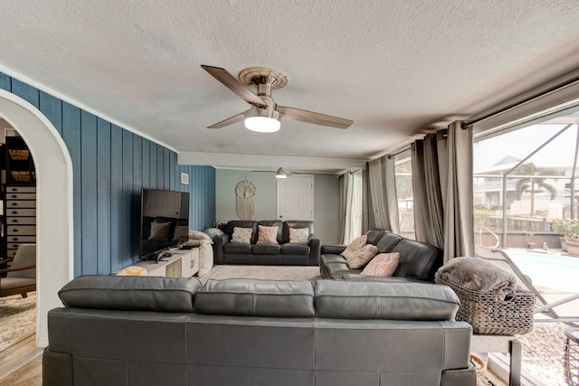 184 Azalea Rd, Edgewater, FL 32141 - living room featuring arched walkways, a ceiling fan, plenty of natural light, a textured ceiling, and wood finished floors