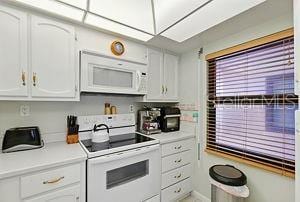 4175 S Atlantic Ave Unit 4050, New Smyrna Beach, FL 32169 - kitchen with white appliances, white cabinetry, and light countertops
