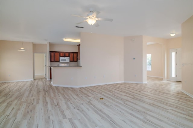 404 Central Mariners Dr, Edgewater, FL 32141 - unfurnished living room featuring light wood finished floors, a ceiling fan, baseboards, and arched walkways