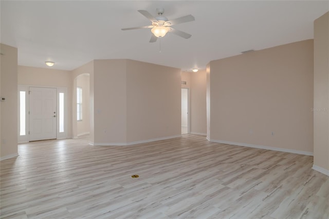 404 Central Mariners Dr, Edgewater, FL 32141 - unfurnished living room with light wood finished floors, ceiling fan, arched walkways, and baseboards