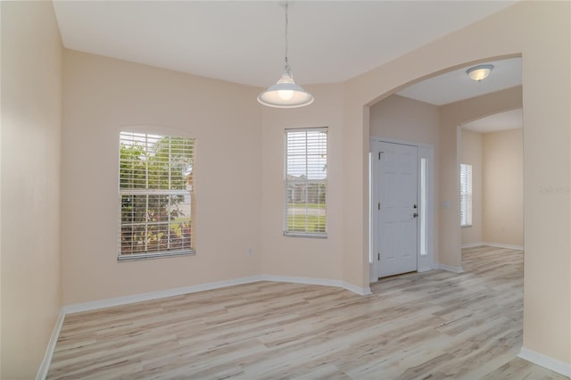 404 Central Mariners Dr, Edgewater, FL 32141 - spare room featuring wood finished floors, arched walkways, and baseboards