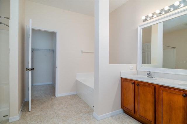 404 Central Mariners Dr, Edgewater, FL 32141 - full bath with double vanity, a garden tub, a walk in closet, tile patterned flooring, and baseboards