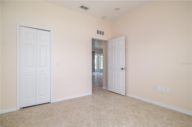 404 Central Mariners Dr, Edgewater, FL 32141 - unfurnished bedroom featuring baseboards, light tile patterned flooring, and a closet